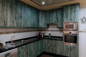 阿德耶Endless Summer Vibes的绿色厨房配有绿色橱柜和微波炉