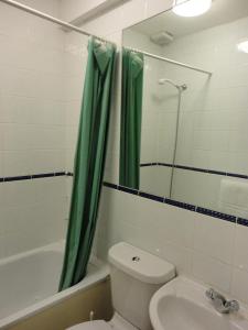 伦敦市景酒店的一间带绿色淋浴帘和卫生间的浴室