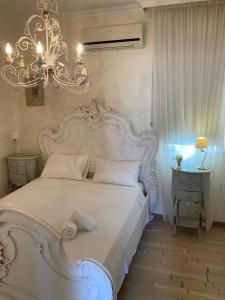 普罗塔拉斯Anna Villa的卧室配有一张白色大床和吊灯。