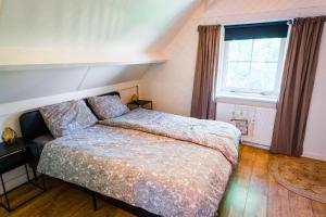 卢特伦Luxe vakantiehuis in het bos met jacuzzi en sauna的一间卧室设有一张床和一个窗口