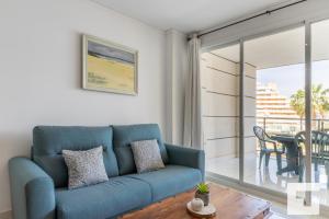 卡尔佩Apartamento Mesana 13 - Grupo Turis的客厅配有蓝色的沙发和桌子