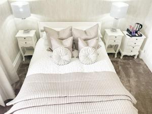 奥本Kenavara House的一间卧室配有带枕头的白色床和2个床头柜。