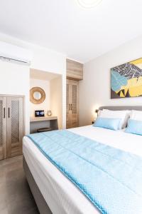 卡利维亚波里吉鲁Bianco Mare Studios-Apartments的卧室配有一张大白色的蓝色床单
