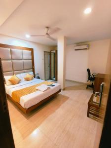 孟买Apex Hotel的一间卧室配有一张大床和一张书桌