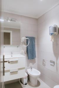 阿德耶Endless Summer Vibes的白色的浴室设有水槽和卫生间。