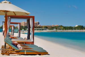 阿布扎比阿布扎比圣瑞吉酒店的海滩上的一组椅子和遮阳伞