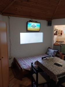 蒂瓦特Petkovic Apartmani 1的一间房间,墙上设有一张桌子和一台电视机
