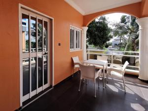 Agbata Guest House的一间拥有橙色墙壁和桌椅的用餐室