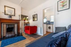 贝尔法斯特Close to city centre home的客厅设有壁炉和红椅