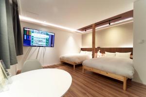 KimobetsuTHE LOBS, RUSUTSU的一间卧室设有两张床,墙上配有电视。