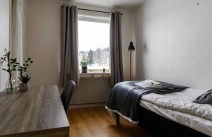 MörsilBrinkeboda Wärdshus的一间卧室配有一张床、一张桌子和一个窗户。