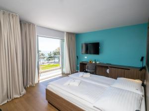 乌马格Hotel Villa Rosetta的一间卧室设有一张大床和一个大窗户