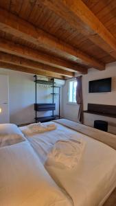 圣皮耶特罗因卡里亚诺Casa Ossan的一张白色大床,位于一个拥有木制天花板的房间