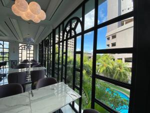 名古屋Grand Eska Hotel & Suites Batam的餐厅设有窗户,享有游泳池的景色