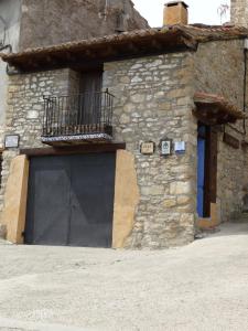 La CubaCasa La Cantonera con zona relax jacuzzi的一座石头建筑,设有黑色车库门