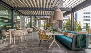 马德里伊鲁尼阿垂姆康福特尔酒店的庭院设有蓝色的沙发和桌椅