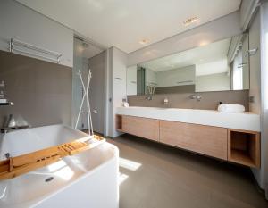 卢森堡Core Luxembourg City- Luxury Brands Street的一间带浴缸和大镜子的浴室