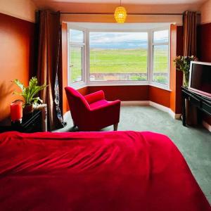锡福斯Liverpool - Cosy Jazzy Beach Home!的一间卧室配有红色的床、椅子和窗户