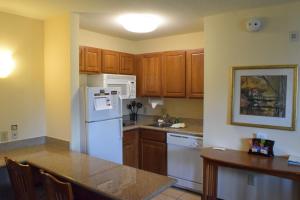 休斯顿西休斯顿宿之桥 - 能源走廊酒店的厨房配有白色冰箱和木制橱柜。