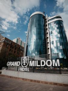 阿拉木图Grand Mildom Hotel的前面有宏伟的百万德标志的建筑