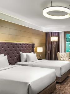 伊斯坦布尔伊斯坦布尔西西里丽笙布鲁酒店的酒店客房带两张床和一个大床头板