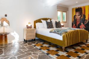 圣安东尼奥派伊维萨岛酒店的卧室配有一张特大号床,墙上挂有绘画作品