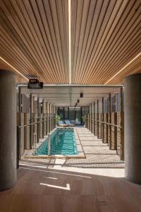 阿德莱德Vibe Hotel Adelaide的一座带木制天花板的建筑中的游泳池