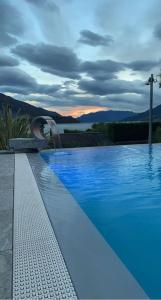多马索Hotel Domaso的蓝色的游泳池,背景是日落
