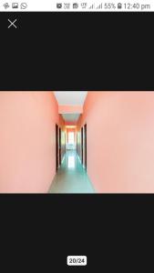 贾巴尔普尔OYO Hotel Erawat Greens的走廊的照片,房间设有粉红色的墙壁