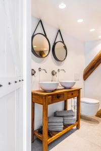 IlpendamAuthentic apartment in farmhouse near Amsterdam的浴室的木桌上设有两个水槽