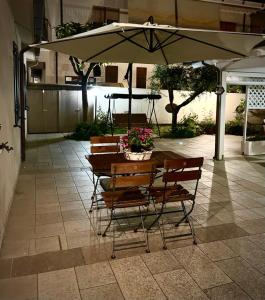佩斯卡拉Casa ideale per la tua vacanza的露台的遮阳伞下的桌椅