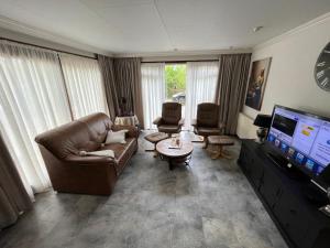 HattemerbroekChalet 58 ''Pollie''的带沙发和平面电视的客厅