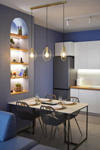 地拉那Vibrant Apartment的用餐室配有桌椅和灯
