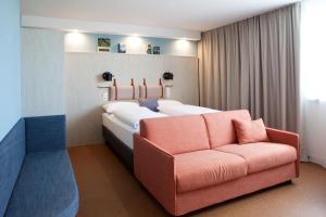 维也纳greet Wien City Nord的一间卧室配有一张大床和一张沙发