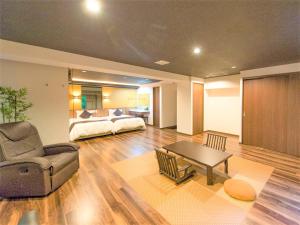 箱根LiVEMAX RESORT Hakone Sengokuhara的客厅配有床、沙发和桌子