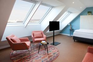 维也纳greet Wien City Nord的阁楼客厅配有2把椅子和电视