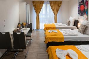 斯图加特Cannstatter Hotel的酒店客房,设有三张带黄床单的床