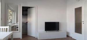 门兴格拉德巴赫Frisch renoviertes Appartement的一间客厅,在白色的墙上配有电视