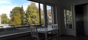 门兴格拉德巴赫Frisch renoviertes Appartement的配有大窗户的客房内的桌椅