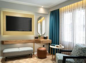 伊斯坦布尔Royan Suites的客厅配有电视、沙发和椅子