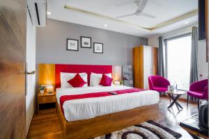 古尔冈Saltstayz Hotel Huda City Center的一间卧室配有一张大床和红色床头板