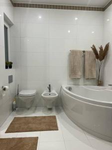 彭布罗克Pembroke St Julians Luxury, Comfort, Location的白色的浴室设有浴缸和卫生间。