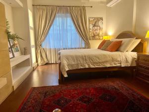 彭布罗克Pembroke St Julians Luxury, Comfort, Location的一间卧室配有一张带窗户和地毯的床