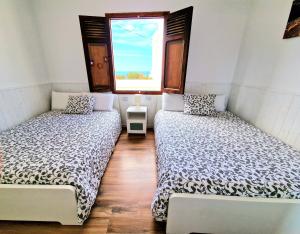 加拉奇科Casa Fa & Na Garachico by HRTenerife Net的带窗户的客房内的两张床