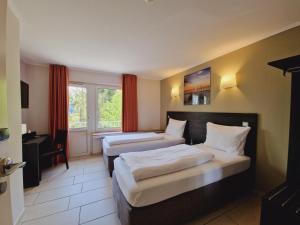 卢森堡BIVIUS Hotel Restaurant Luxembourg的酒店客房设有两张床和窗户。