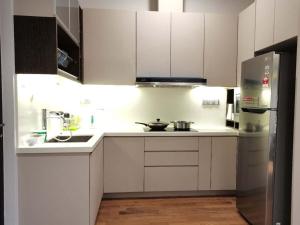 云顶高原Geo 38 Residence Genting Highland的厨房配有白色橱柜和不锈钢冰箱