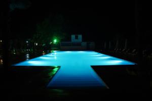 拉戈代希Wald Hotel Lagodekhi的游泳池在晚上点亮,灯光蓝色