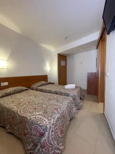 滨海托萨P&R hostals Codolar的酒店客房设有两张床和一台平面电视。