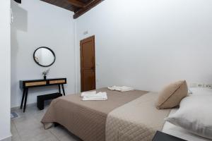 法拉萨纳En Plo Beachfront Rooms的一间卧室配有一张带镜子和桌子的床