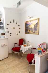伊斯坦布尔画廊酒店的一间设有桌椅和墙上时钟的房间